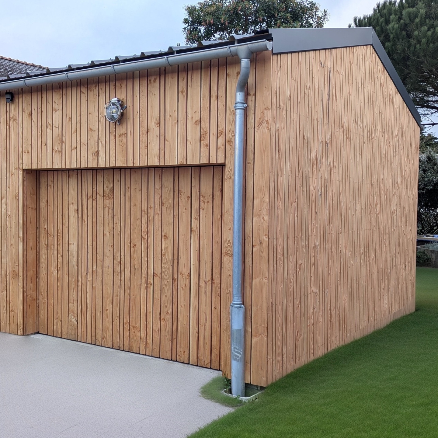 Porte de garage basculante en bois assortie à la façade